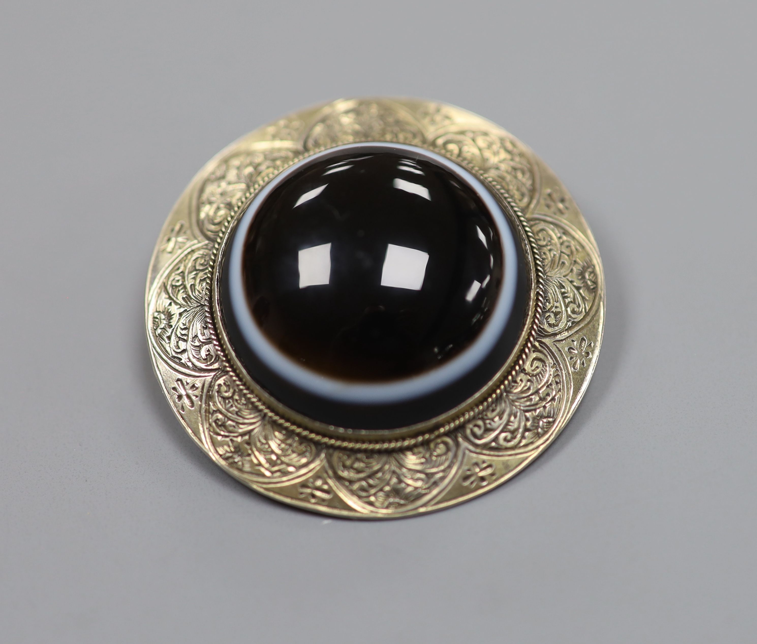 An engraved gilt white metal and banded agate set circular brooch